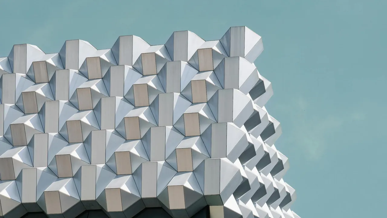 Geometrische Fassade vor hellem Himmel